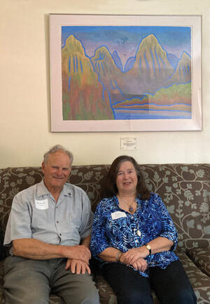 Bob Venning and Laura Siegel Venning sitting beneath her painting of the Li River in China installed on the 4th floor I-House Berkeley, resident lounge. 